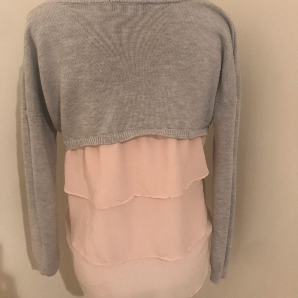 Gray sweater with ruffle back.